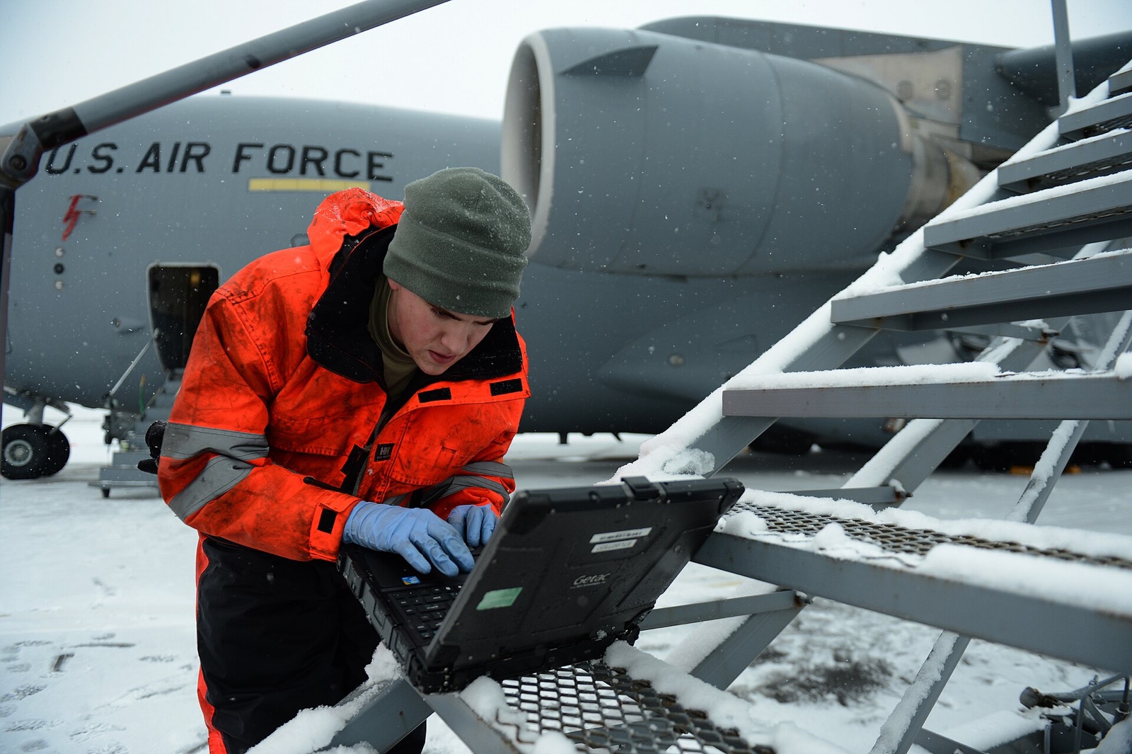 A technician references a technical order on his laptop